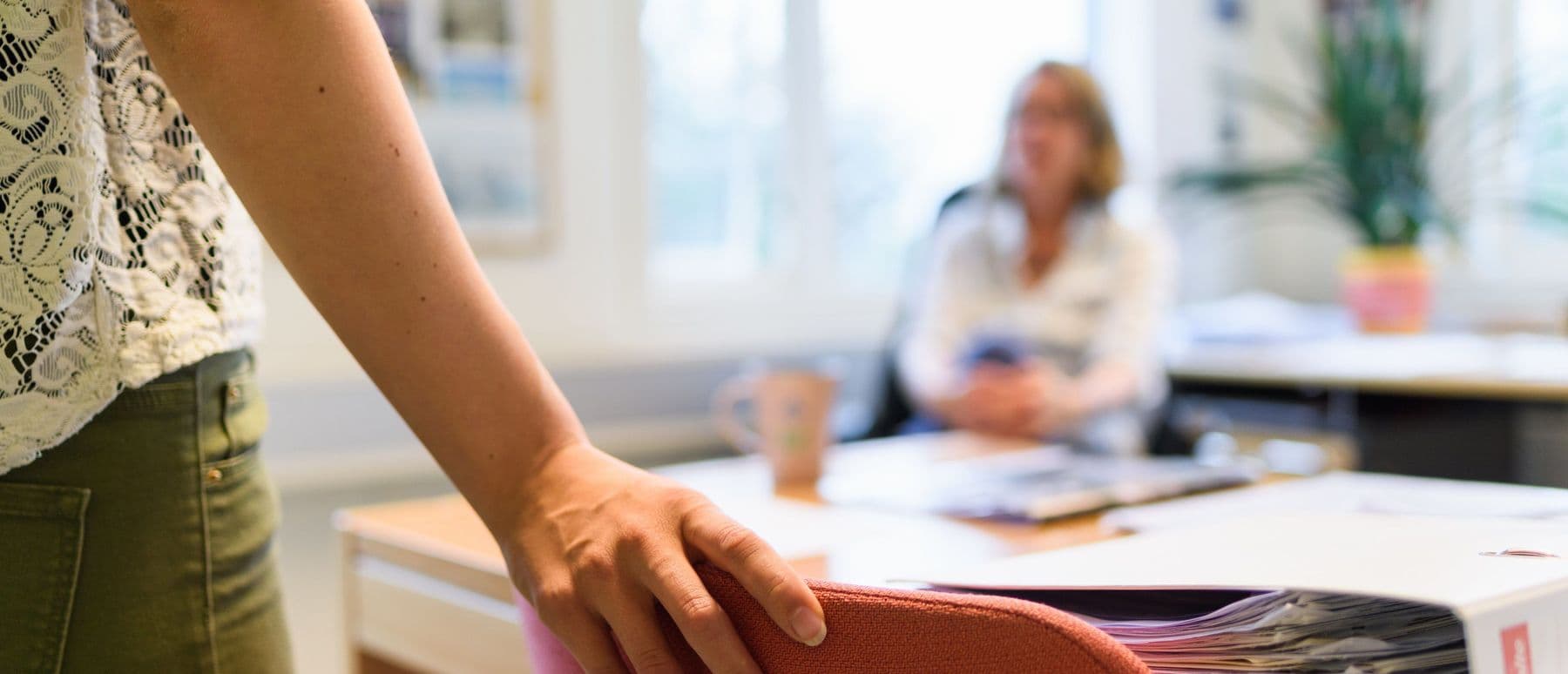 Hönd styður við stólbak